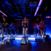 picture of a dark room with blue lights and rows of bikes for cycling class