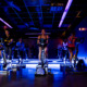 picture of a dark room with blue lights and rows of bikes for cycling class